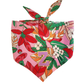 A bandana with a tropical print featuring various colorful leaves and a customizable patch, designed for small to medium dogs.