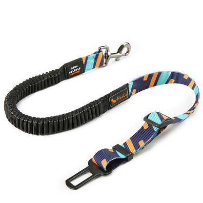 An adjustable shock-absorbing dog seatbelt with a black body, and a pattern of orange and blue geometric shapes on a portion of the fabric.