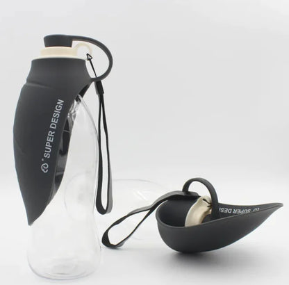 A portable pet water bottle with a flip-top lid, partially filled with water, and an attached strap for carrying. The bottle appears to be made of clear plastic and the lid is black